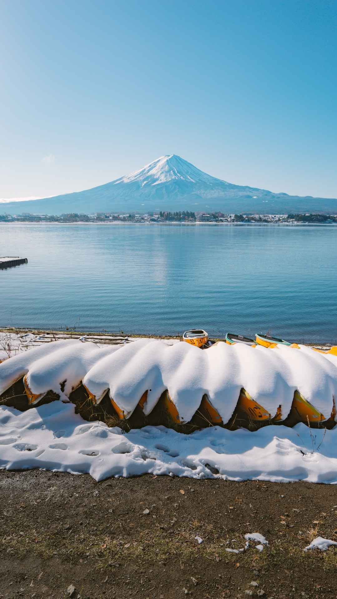 Snow-covered Mount Fuji and lakeside boats in winter